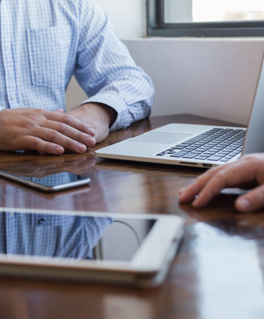 Image of men at desk with mobile devices Image of men at desk with mobile devices